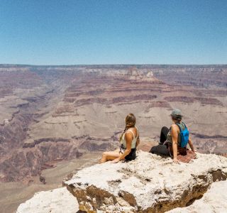 Hiking Friends sitting at Edge of Grand Canyon